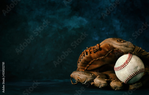 Baseball glove with ball close up in studio with dark texture backdrop, copy space for sport graphic concept. photo
