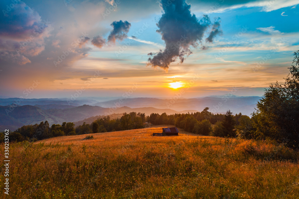 Fototapeta premium Beautiful countryside road landscape with old barn at sunset