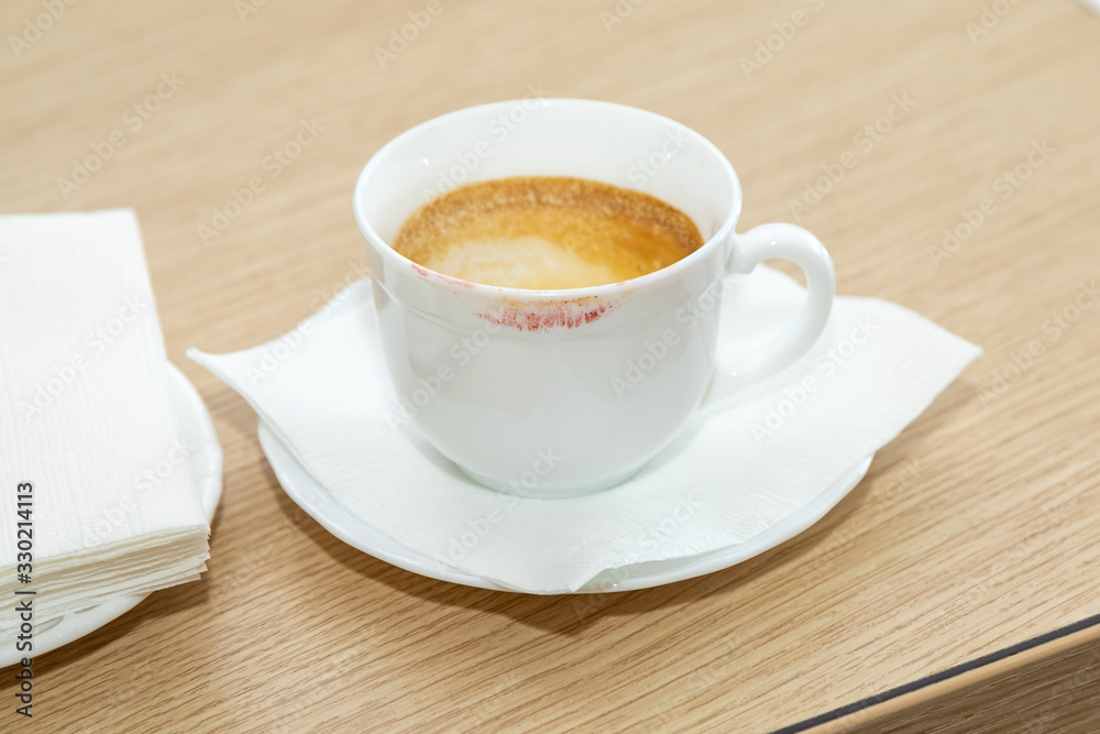 Fototapeta premium White Cup of Drunk Coffee with a Trace of Lipstick. Empty dirty dishes on the table