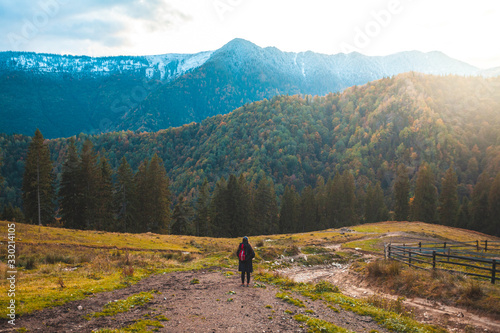 Girl walking on mountain trail near a forest, serenity and freedom
