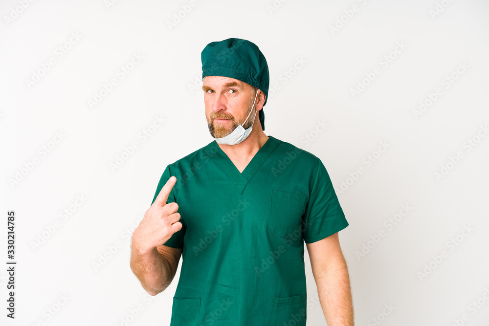Surgeon senior man isolated on white background pointing with finger at you as if inviting come closer. Surgeon senior man isolated on white background pointing with finger at you as if inviting come closer.