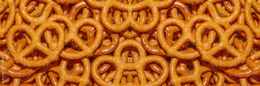 Salted Bavarian pretzel close-up, beer snack - web banner. Mini pretzel, fresh baked goods. Background or texture of fresh baked pastry. Background of pretzels. Salted Bavarian pretzel close-up, beer snack - web banner. Mini pretzel, fresh baked goods. Background or texture of fresh baked pastry. Background of pretzels.