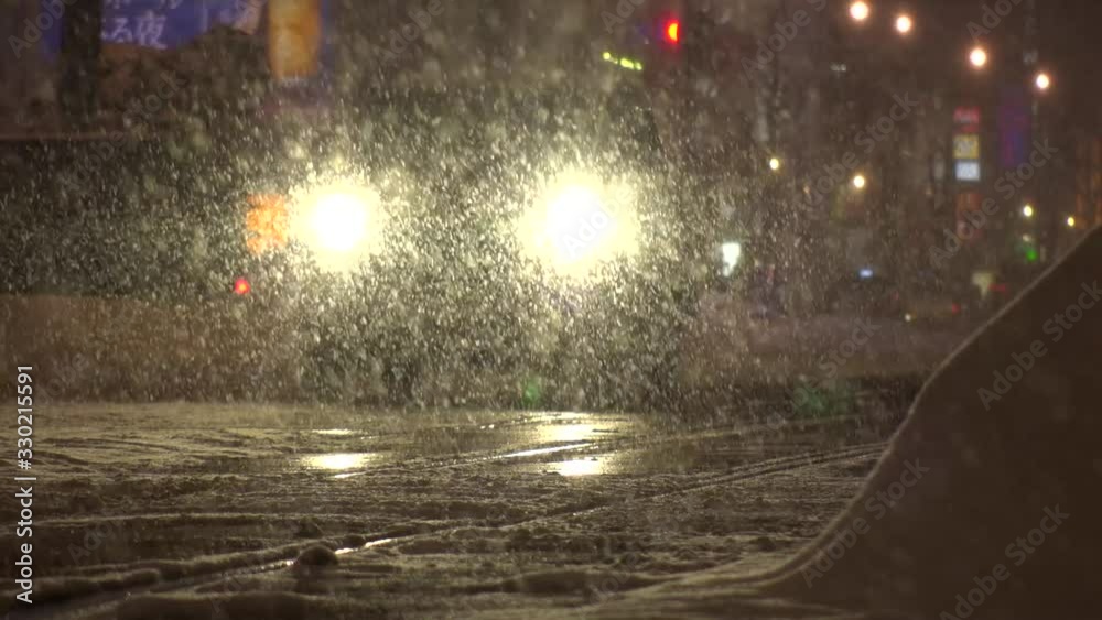 SAPPORO, HOKKAIDO, JAPAN - FEB 2020 : Snow scenery around Susukino city area at night. Soft snow falling at downtown street. Concept of Japanese winter and cold snowing season. Slow motion shot. SAPPORO, HOKKAIDO, JAPAN - FEB 2020 : Snow scenery around Susukino city area at night. Soft snow falling at downtown street. Concept of Japanese winter and cold snowing season. Slow motion shot.