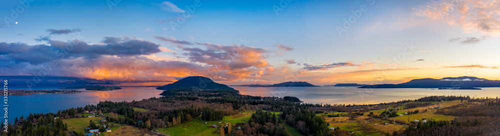 Panoramic Moonrise Over Lummi Island, Washington. Aerial view of Lummi Island during a glorious sunrise with a view to Lummi Mountain and Bellingham Bay. 