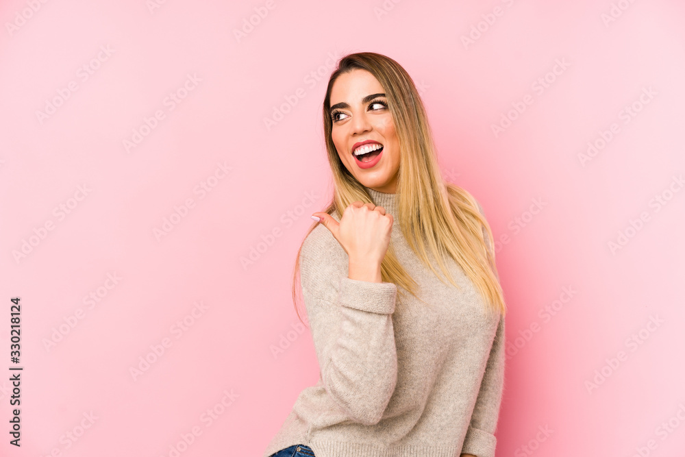Middle age woman over isolated background points with thumb finger away, laughing and carefree. Middle age woman over isolated background points with thumb finger away, laughing and carefree.