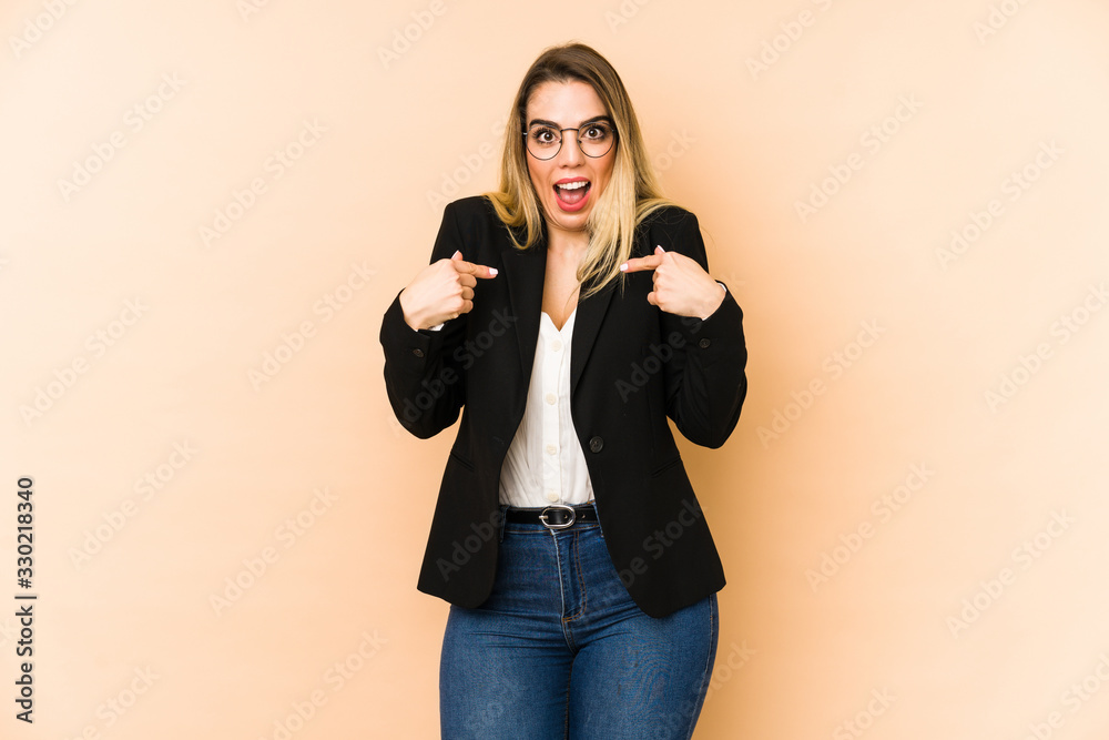 Middle age business woman isolated on beige background surprised pointing with finger, smiling broadly. Middle age business woman isolated on beige background surprised pointing with finger, smiling broadly.