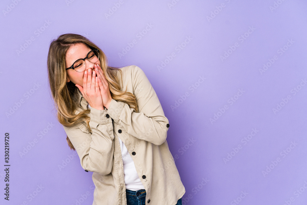 Young caucasian woman isolated on purple background laughing about something, covering mouth with hands. Young caucasian woman isolated on purple background laughing about something, covering mouth with hands.