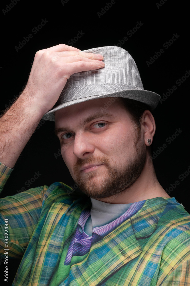 handsome confident stylish bearded man in green blazer taking off grey hat and looking at camera isolated on black handsome confident stylish bearded man in green blazer taking off grey hat and looking at camera isolated on black