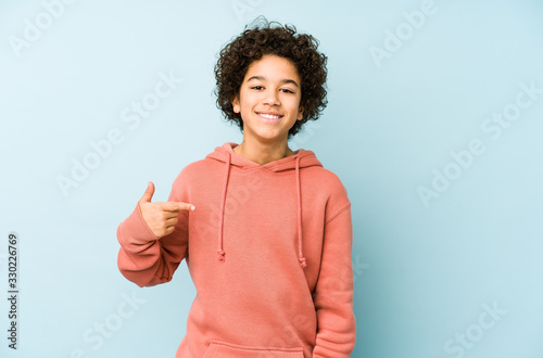 African american little boy isolated person pointing by hand to a shirt copy space, proud and confident photo