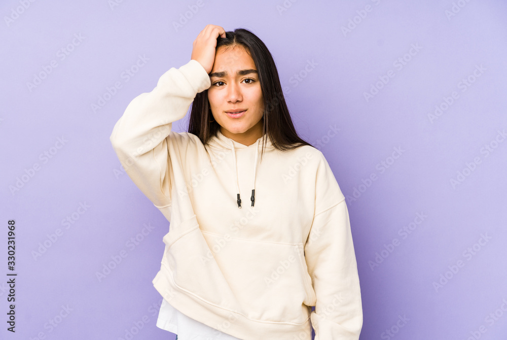 Young woman isolated on a purple background tired and very sleepy keeping hand on head. Young woman isolated on a purple background tired and very sleepy keeping hand on head.