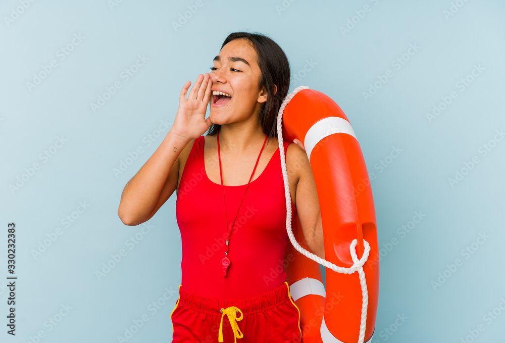 Φωτογραφία Young asian lifeguard woman isolated shouting and holding palm near opened mouth