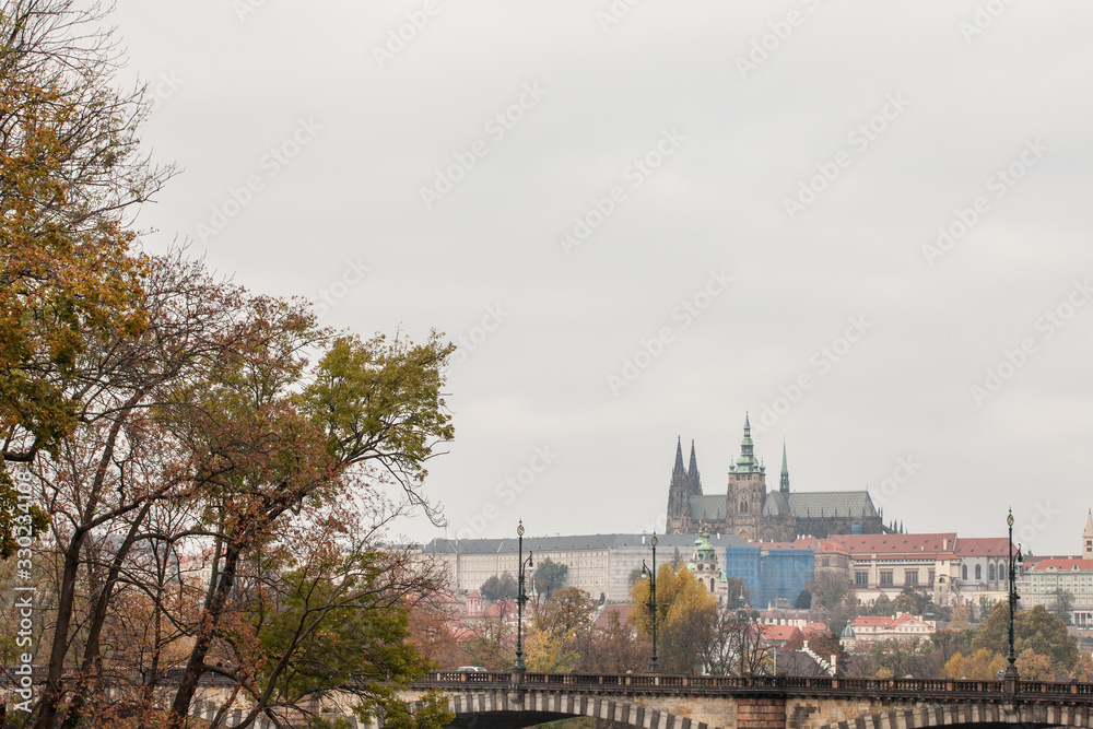Naklejka premium Panorama of the Old Town of Prague, Czech Republic, in autumn, at fall, with Hradcany hill and the Prague Castle with the St Vitus Cathedral (Prazsky hill) seen from Vltava river. 