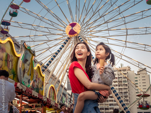 happy asia mother and daughter have fun in amusement carnival park with farris w Fototapet