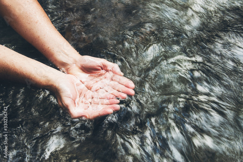 Soaking hands in the clear river  Scooping up the water
