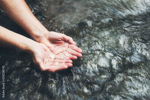 Soaking hands in the clear river  Scooping up the water