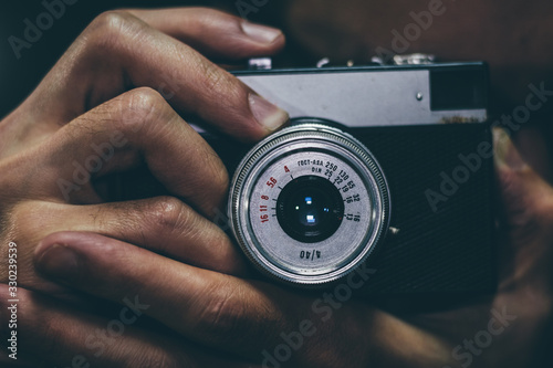 Man taking a photo with an old vintage film camera, close up. photo