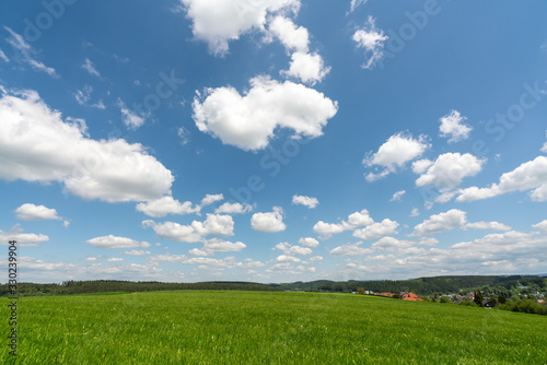 Beautiful rural scene  blue sky  white clouds  and green grass
