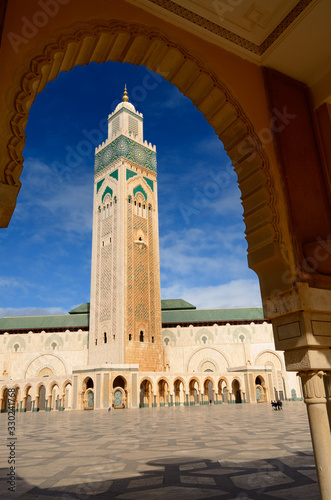 Hassan II mosque minaret framed by a plaza arch in Casablanca Morocco