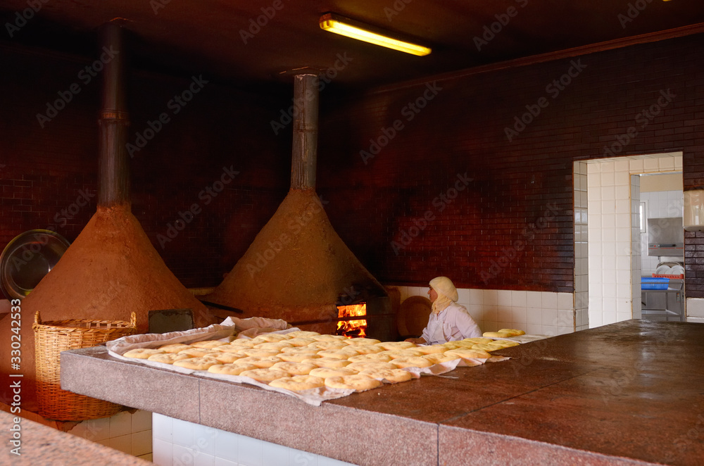 Moroccan woman baking bread in a wood burning oven early in the morning at El Jedida Moroccan woman baking bread in a wood burning oven early in the morning at El Jedida