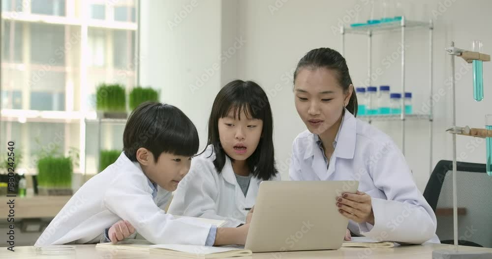 In Science Class Teacher and Students Research Information in Computer for Science Project. Science and Education Concept. In Science Class Teacher and Students Research Information in Computer for Science Project. Science and Education Concept.
