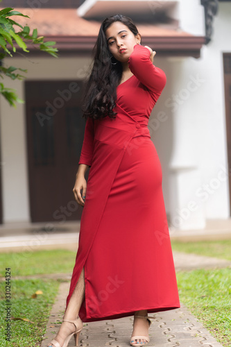 fashion outdoor photo of beautiful woman in luxurious red dress posing