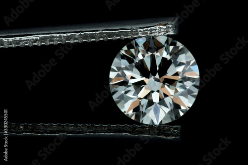Flat View Of Big Round Diamond Held By Tweezers