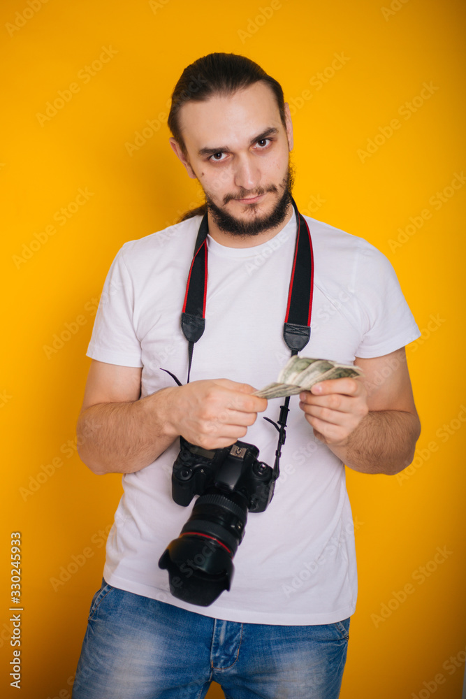 The photographer is holding money. A guy in a white T-shirt with a camera on a yellow background holds dollars in his hands. Photographer Salary The photographer is holding money. A guy in a white T-shirt with a camera on a yellow background holds dollars in his hands. Photographer Salary