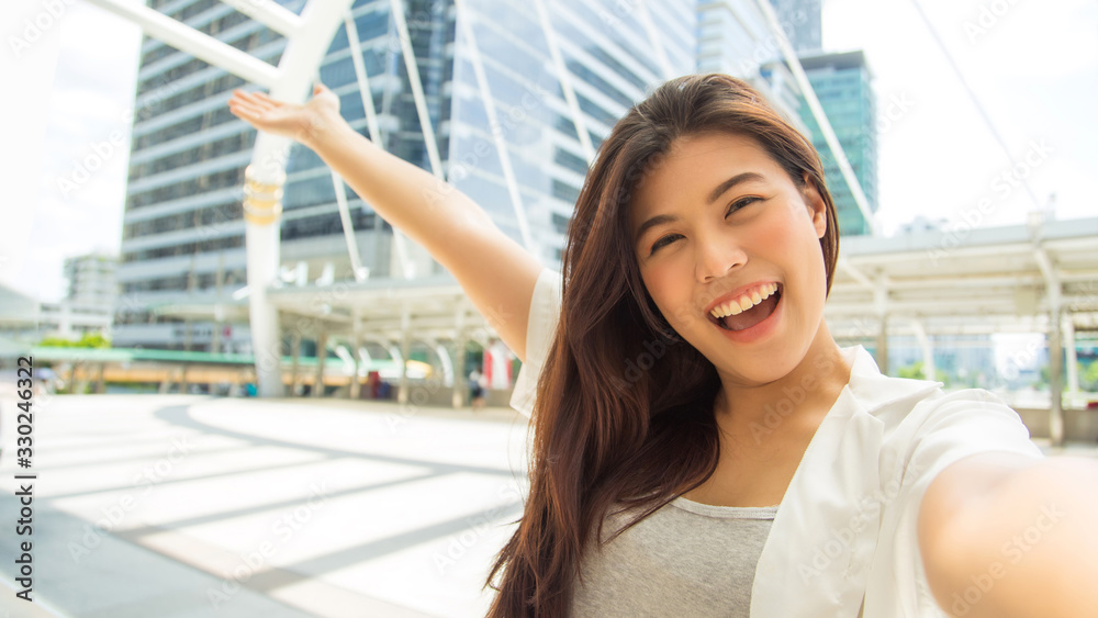 portrait beautiful Asian charming girl selfie from her camera with smile on face on modern footbridge and outdoor square