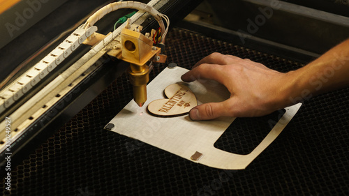 Laser cutting beam high precision on a plywood sheet. Modern technology of wood cutting. laser cut wooden 3d symbol of valentine's day. Industrial laser engraving. CNC laser. Masterclass, workshop