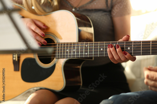 Music Playing Workshop for Beautiful Young Lady. Caucasian Couple Sitting with Acoustic Guitar. Girl Hands with Colored Nails Touching Strings. Male Professional Performer Teaching Chords