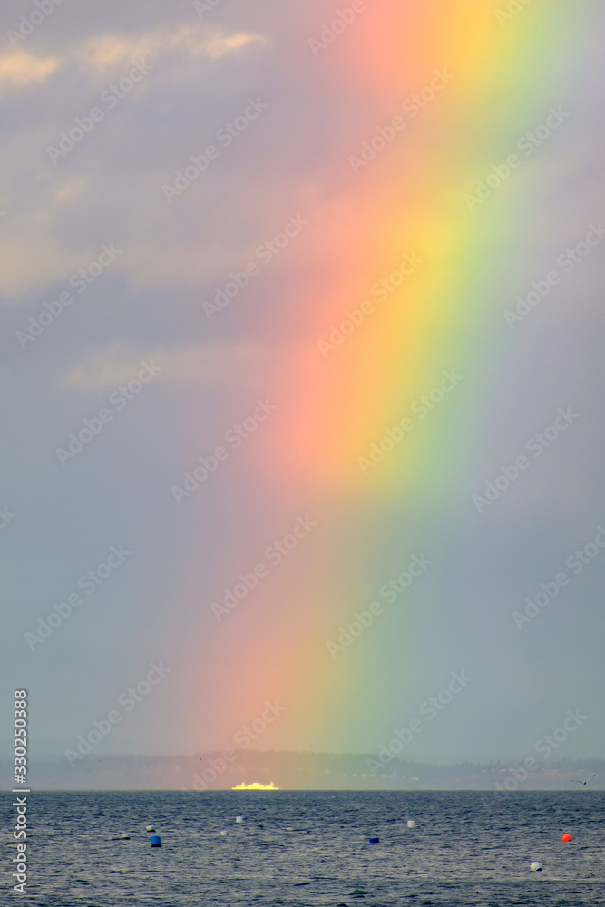 A white boat passes through a colorful rainbow A white boat passes through a colorful rainbow