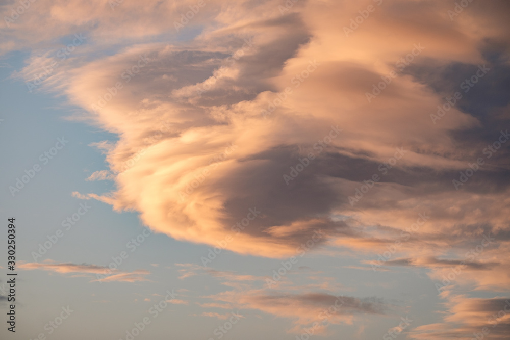 A large golden lenticular cloud formation at sunset