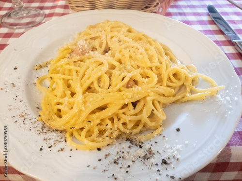 A plate of carbonara with a sprinkling of pepper