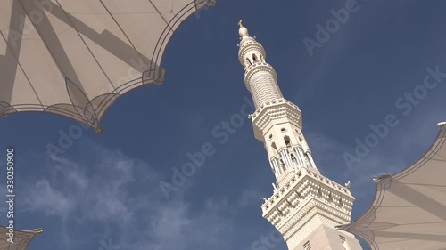 Minaret of the Prophet's Mosque behind protective umbrellas in Medina, Saudi Arabia photo