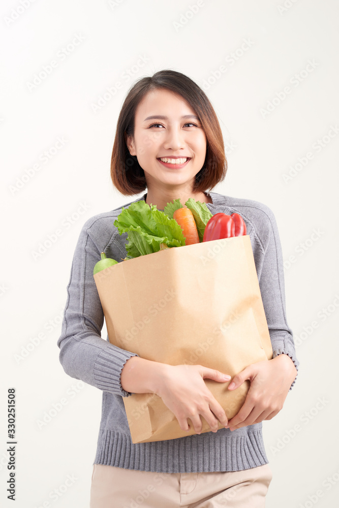 Woman holding grocery shopping bag on white background Woman holding grocery shopping bag on white background