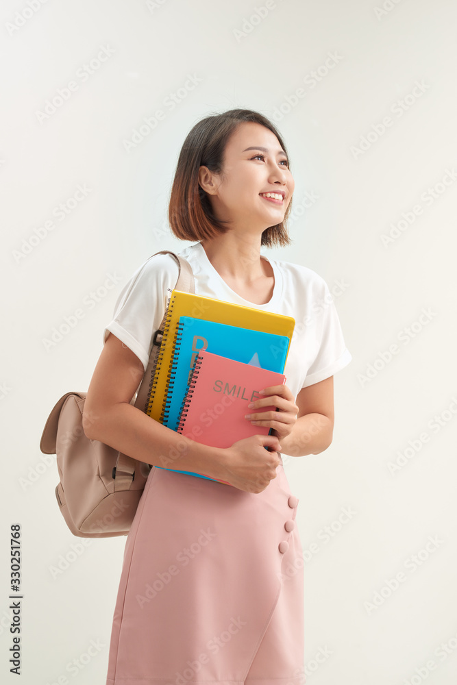 Young asian girl student with backpack hold books isolated on white background studio portrait Young asian girl student with backpack hold books isolated on white background studio portrait