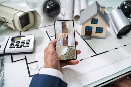 Person Hand Using Home Security System On Mobilephone