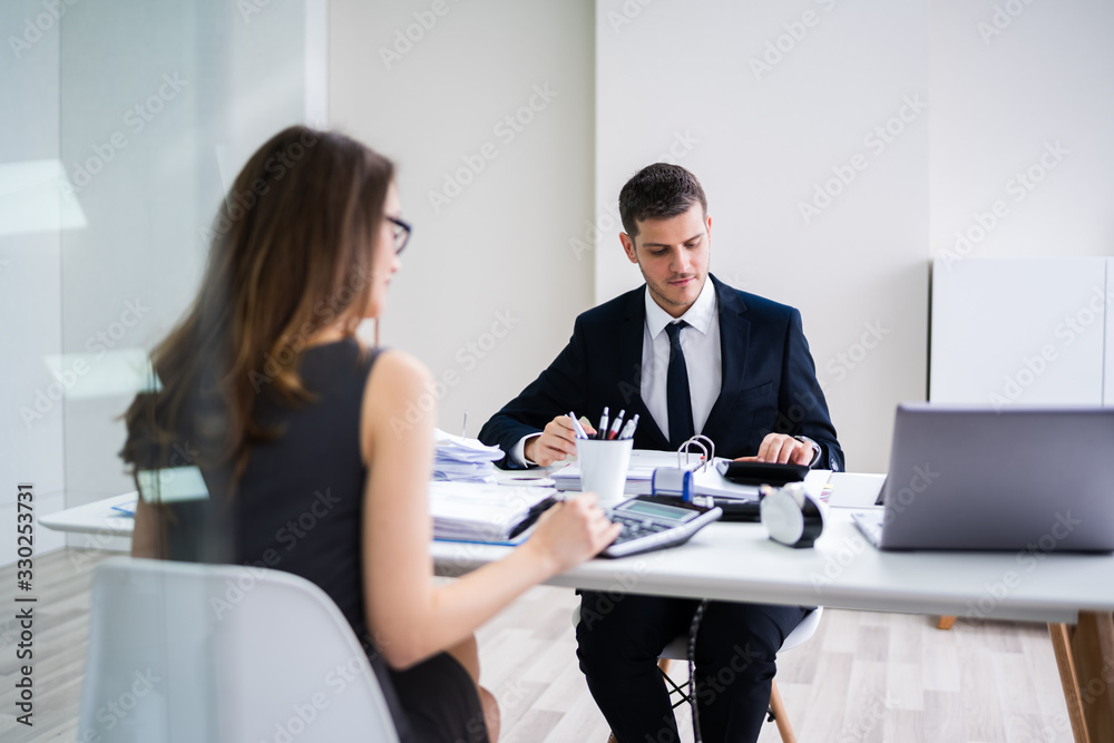 Two Businesspeople Calculating Financial Statement Two Businesspeople Calculating Financial Statement