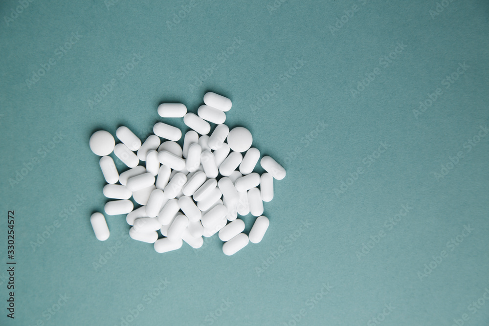  Virus protection and 2019-ncov. Layout of Flatley tablets. A pile of white tablets on a blue background is isolated.