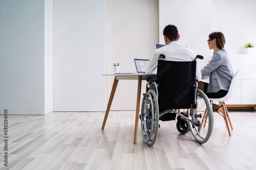 Disabled Businesswoman Sitting With Her Partner In Office Disabled Businesswoman Sitting With Her Partner In Office