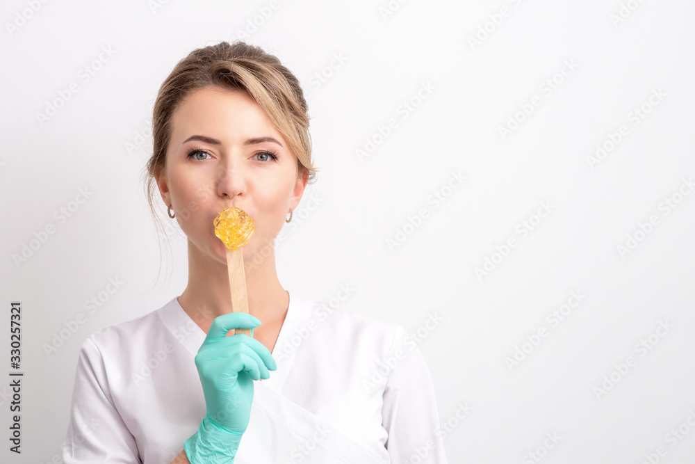 Beautician holds stick with wax. Beautician holds stick with wax.