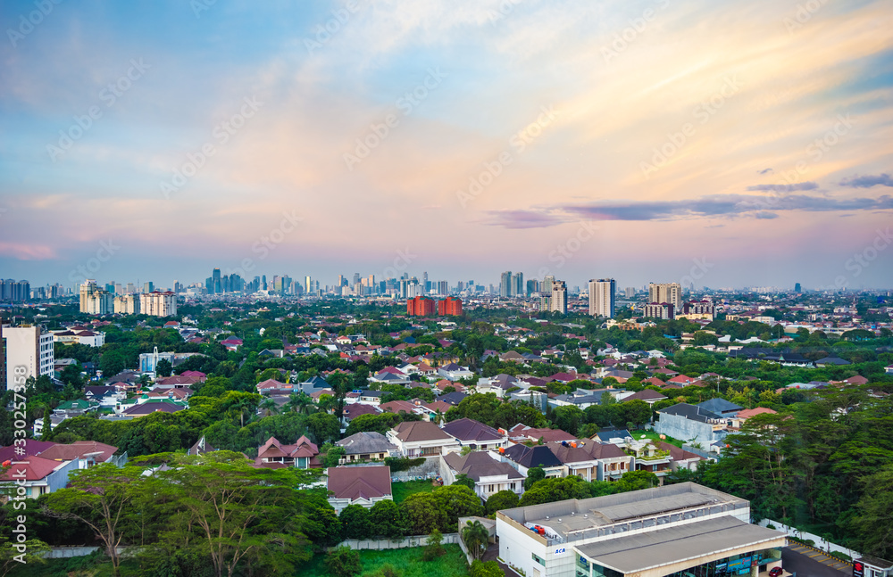 Jakarta, Indonesia - 30th December 2018: South Jakarta cityscape, taken at sunset. Jakarta CBD. High rise buildings in the background, luxury houses in the foreground.