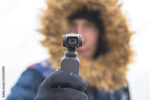 A man travels and takes off everything seen on the action camera . Focus on action camera. Winter.