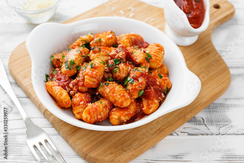 Homemade italian gnocchi with red tomato sauce and parmesan cheese. photo