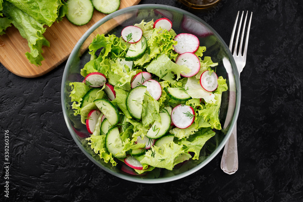 Vegetarian vegetable salad of radish, cucumbers, lettuce .  Healthy vegan food.