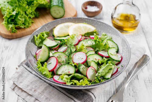 Vegetarian vegetable salad of radish, cucumbers, lettuce . Healthy vegan food.