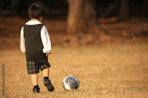 一人でサッカーボールを蹴って遊ぶ男の子