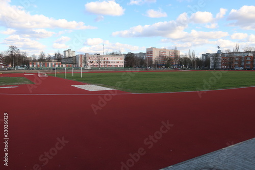 sports ground with a large football field and a red running track