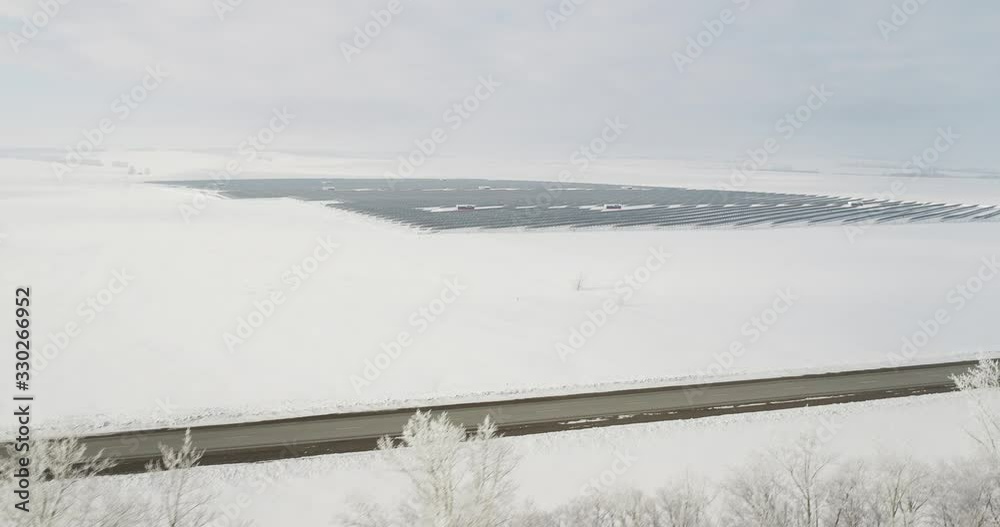 Solar station, power plants, panels farm in snow clear field / Wide shot at winter sunny day - Aerial drone view Solar station, power plants, panels farm in snow clear field / Wide shot at winter sunny day - Aerial drone view