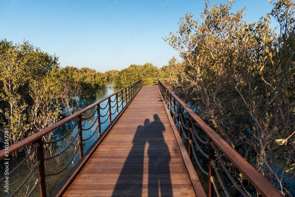 Couple shadow as they enjoy sunset at Mangrove park in Abu Dhabi